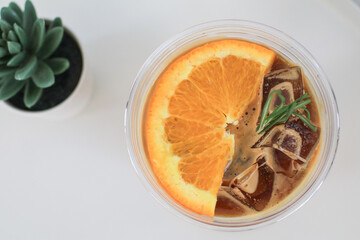 Coffee with orange juice on white table. Trendy summer Refreshing coffee drink. Menu fresh fruit,