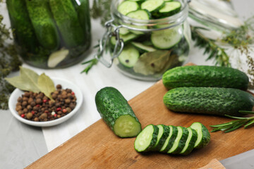 Fresh cucumbers and spices on light table, closeup. Preparation for pickling