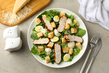 Tasty Caesar salad with chicken on light grey table, flat lay