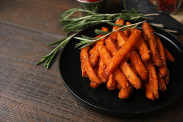 Sweet potato fries and rosemary on wooden table, closeup