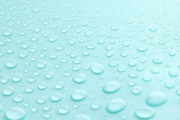 Water drops on turquoise background, closeup view