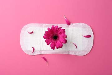Menstrual pad with flower on pink background, top view © New Africa