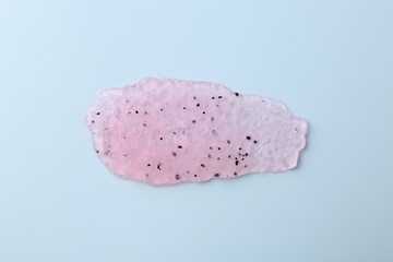 Smear of body scrub on light blue background, top view
