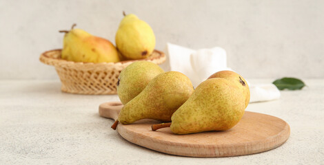 Wooden board with ripe pears on white background