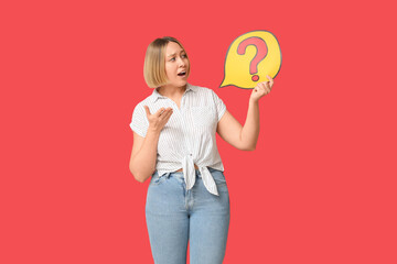 Shocked adult woman holding speech bubble with question mark on red background