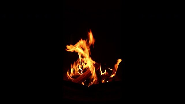 On a dark fall night, a fire is made with firewood in the brazier