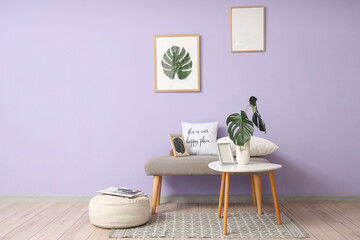 Interior of room with soft bench, table and palm leaves