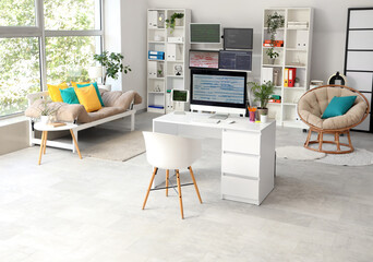 Interior of light programmer's office with desks, shelf units and sofa