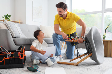 Father and his little son with instructions assembling chair at home