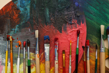 Artist brushes and palettes on beige background, closeup