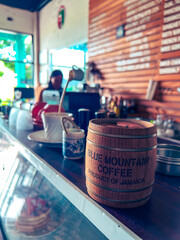 blue mountain coffee and its barista blurred in the background