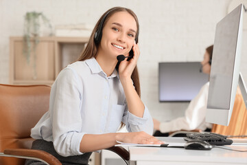 Female technical support agent working at table in office