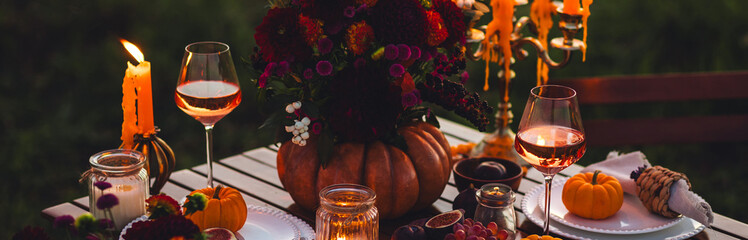 Banner. Garden romantic party outside with wine, cheese, fruits. Field or meadow, family event, cozy autumn atmosphere, fall vibes. Wooden furniture, pumpkin with flowers as centrepiece, fresh dahlia