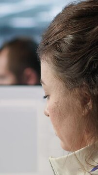 Smiling IT engineer in data center using PC to find misconfigurations affecting rackmounts. Cheerful woman checking servers bottlenecks leading to sluggish data transfer rates, camera A close up