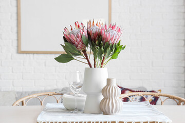 Table setting with protea flowers in dining room