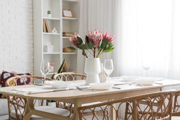 Table setting with protea flowers in dining room