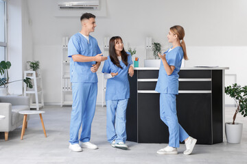 Medical interns talking near reception in clinic