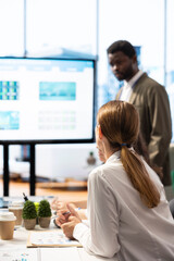Business professionals engaging in a strategy session during meeting, utilizing an interactive...