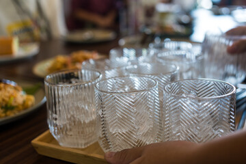 Waiter served many glass with ice to customer in restaurants