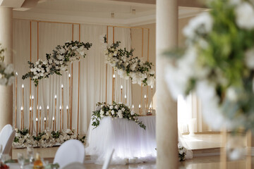 A table decorated with white flowers for a wedding celebration. Banquet decorator services. High quality photo