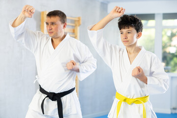 Obraz premium Individual karate lesson for teenager - fighting position of teenager and coach during karate training