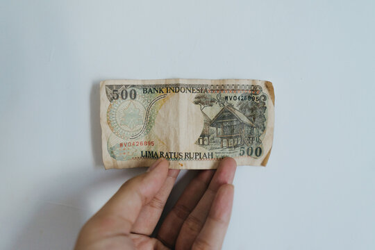 Hand holding old rupiah banknote with a nominal value of 500