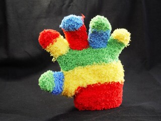 Children's glove to keep children's hands warm, symbolizes that everything is okay and positive. Hand gesture colorful woolly signal of lost object.