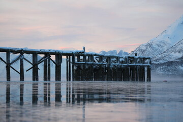 Norwegian wooden pier with fjord mountain backround