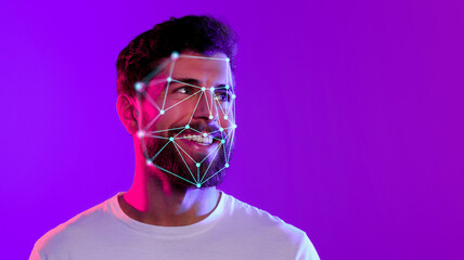 A smiling young man displays a digital overlay of facial recognition technology on his face. The...