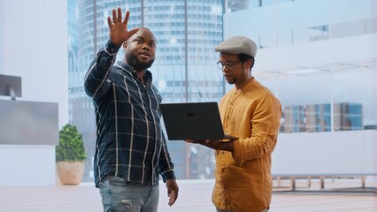 Real estate agent advising clients on an office leasing contract, presenting a layout blueprint of new space for rental. Planning a business headquarters relocation. Property investing. Camera B.