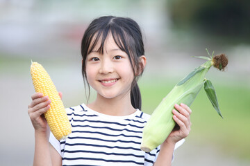 とうもろこしを持つ女の子