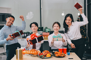 full length view of a group of business team wearing red Santa hat and exchange gift box together...