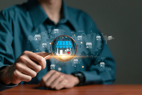 Local marketplace e-commerce concept, local seo strategy, local search optimization, small business and retail. Businessman using magnifying glass focus to local marketplace icon on virtual screen.