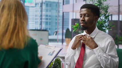 Anxious inexperienced job applicant feeling very uncomfortable during interview, being insecure and overwhelmed while he talks about himself and his qualifications with the HR team. Camera A.