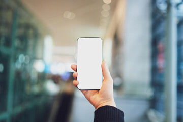 Hand Holding a Smartphone Against Blurred Background in Modern Setting