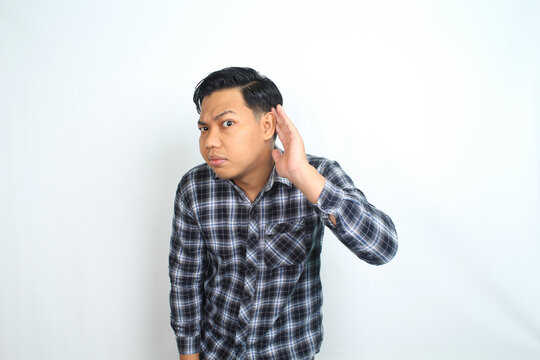 attractive serious asian man do eavesdropping gesture show curiosity wearing casual blue plaid shirt isolated on white background