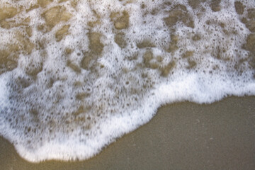 Beautiful soft wave on a sandy beach. Beach sand with soft wave. Summer vacation concept