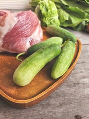Raw pork and cucumber on wood board