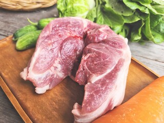 Raw pork and vegetable on wood board