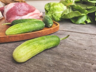 Raw pork and cucumber on wood board