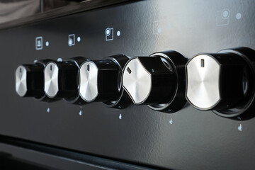 Close-up of a gas stove control panel knob with handle turned on in a home kitchen.