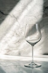 Empty wine glass on marble, shadow play, translucent elegance