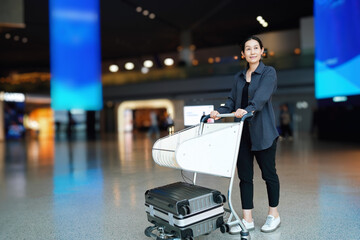 Confident Traveler in Airport with Luggage Cart Ready for Adventure