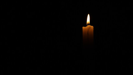 Candlelight flickering in the dark, creating a somber and contemplative atmosphere. Ideal for projects related to remembrance, loss, or spirituality
