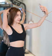 Shot of sporty woman taking selfie in gym.