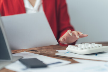 Focused on Finance: A close-up shot of a woman's hands meticulously working on financial documents,...