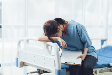 Exhausted Nurse: A somber image of a female nurse, her head resting on a hospital bed, reflecting the emotional and physical toll of her demanding profession.
