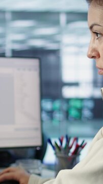 Smiling IT engineer in data center using PC to find misconfigurations affecting rackmounts. Cheerful woman checking servers bottlenecks leading to sluggish data transfer rates, camera B close up