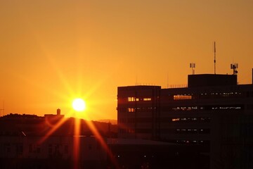 a hopeful sunrise over a hospital symbolizing new treatments