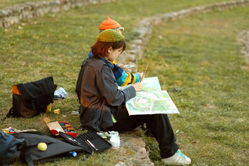 two young and innovative female artists conducting an outdoor painting lesson. Surrounded by...